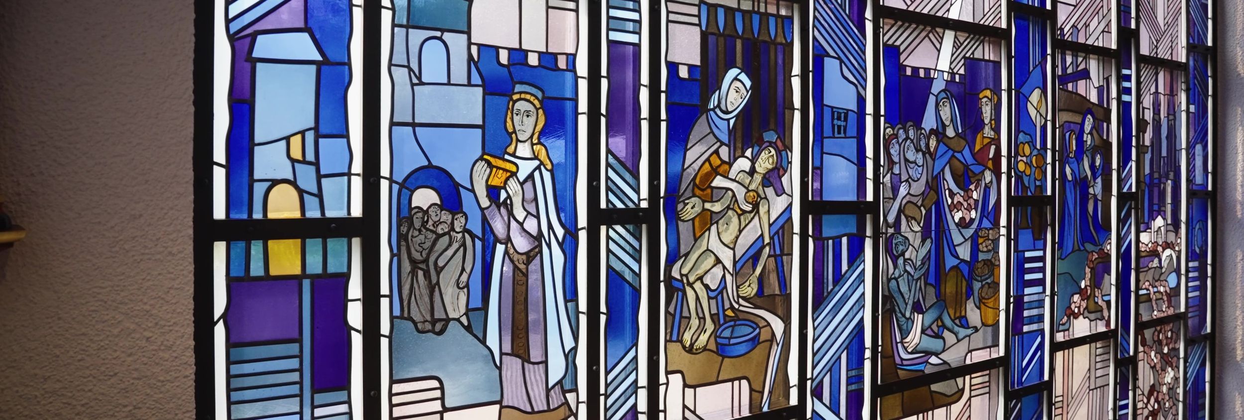 Buntes Kirchenfenster mit religiösen Szenen und Figuren